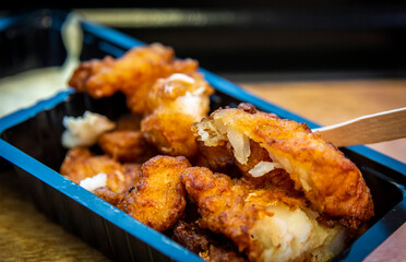 Top view of the popular Netherlands fried fish snack in a black box.