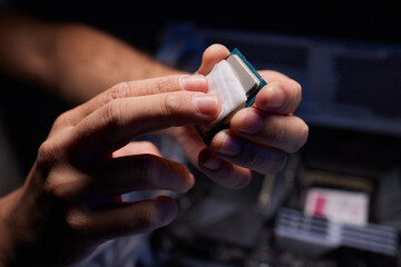 Cropped image of an engineer showing a computer microchip on the foreground