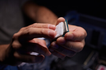 Cropped image of an engineer showing a computer microchip on the foreground