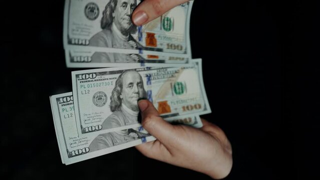 close-up of male hands counting stack of hundred-dollar US banknotes. a businessman is counting cash. концепція інвестицій, гроші обміну, бриви або коррупції. selective focus.	