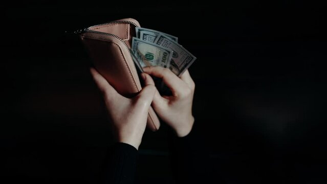 close-up of male hands counting a stack of hundred-dollar US banknotes. a businessman is counting cash. the concept of investment, money exchange. selective focus. takes money out of the wallet