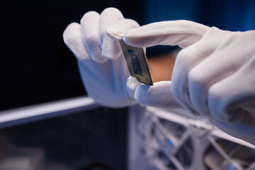 Cropped image of an engineer showing a computer microchip on the foreground