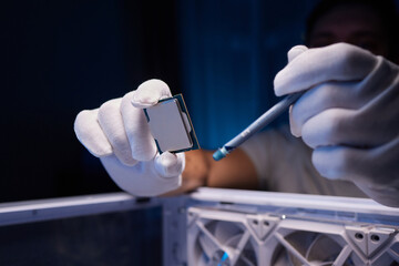 Cropped image of an engineer showing a computer microchip on the foreground