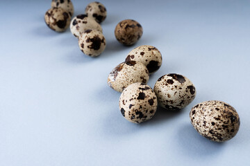 Fototapeta premium Composition with Easter eggs and long shadows from glass on a blue background. Blue background with quail eggs.