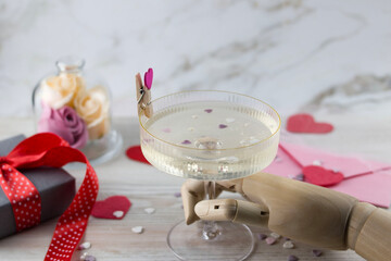 Background or greeting card for Valentine's Day. wooden hand holding a glass of heart inside a glass of champagne.