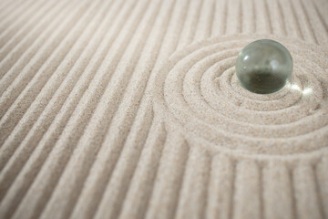 Fototapeta na wymiar Miniature sand zen garden with a glass sphere and geometric dunes, abstract texture backdrop