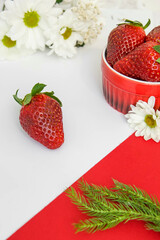 Truskawki w misce i białe kwiaty Margaretki © Katarzyna