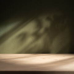 Empty table on khaki green texture wall background. Composition with leaves shadows on the wall and...
