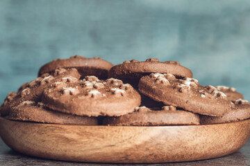 Delicious sweet cocoa cookies biscuits on a wooden plate