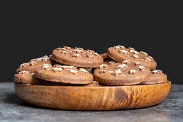 Delicious sweet cocoa cookies biscuits on a wooden plate