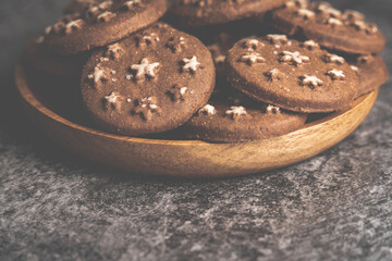 Delicious sweet cocoa cookies biscuits on a wooden plate