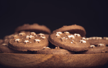 Delicious sweet cocoa cookies biscuits on a wooden plate