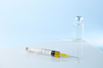 syringe for injectable medication on blue background