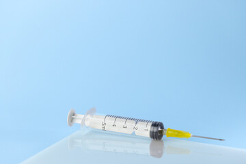 syringe for injectable medication on blue background