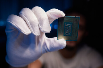 Cropped image of an engineer showing a computer microchip on the foreground