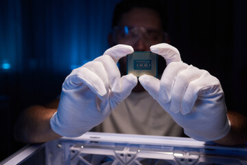 Cropped image of an engineer showing a computer microchip on the foreground