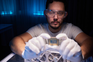 Cropped image of an engineer showing a computer microchip on the foreground