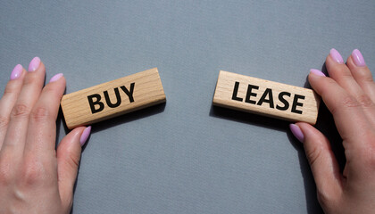 Buy or Lease symbol. Concept word Buy or Lease on wooden blocks. Businessman hand. Beautiful grey...