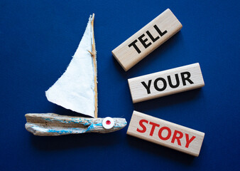 Tell your story symbol. Wooden blocks with words Tell your story. Beautiful deep blue background...