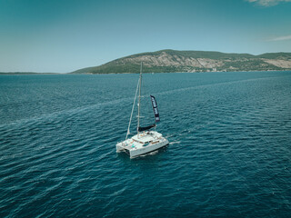 Catamaran Sailing with Black Sail in Calm Sea
