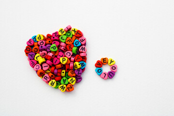 Phrase love you next to a heart formed with colorful beads to make necklaces and bracelets