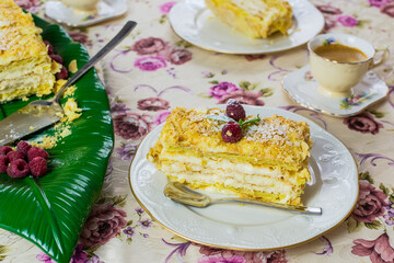 A piece of dessert Napolen garnished with raspberries