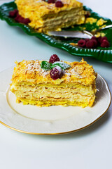 A piece of dessert Napolen garnished with raspberries
