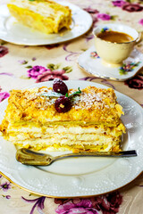 A piece of dessert Napolen garnished with raspberries