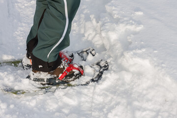 Detail, close view  to snowshoes,  side view, man walks in the snow.