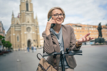 Woman with electric kick scooter use mobile phone smartphone make call