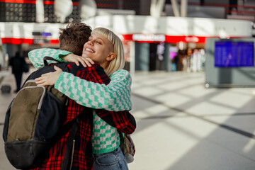 A young affectionate couple is hugging on train station.