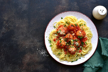 Spaghetti pasta with meatballs in tomato sauce. Traditional dish of italian cuisine. Top view with copy space.