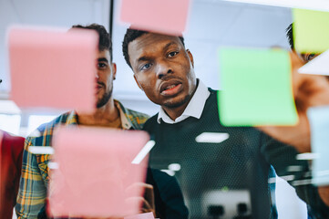 African american man using sticky notes during a meeting in the office