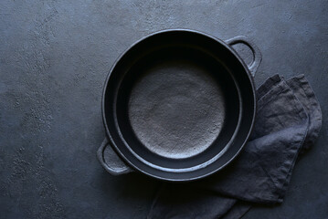Culinary background with empty cast iron pan , napkin and spoon. Top view with copy space.