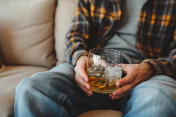 Foto op Plexiglas Alcoholic sitting on the sofa with a glass of alcohol, alcoholism concept. Background with selective focus © top images