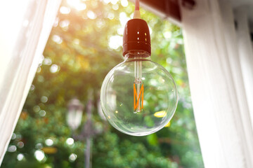 Turned off light bulb in a business office on a natural green background.