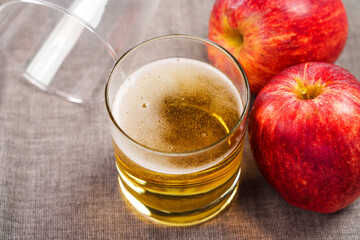 Apple cider foam with sparkling bubbles on table with red organic apples