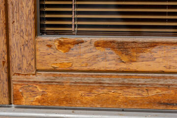 weathered wooden door, maintenance needed, peeled varnish caused by sunny and rainy weather.