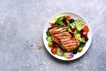 Grilled chicken fillet with fresh vegetable salad. Top view with copy space.