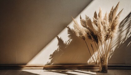 beautiful shades of neutral pampas grass and reeds makes for an aesthetic background with sunlight casting shadows on the wall giving off parisian vibes - obrazy, fototapety, plakaty