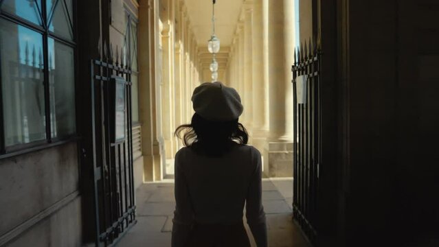 Woman Walking Through Historical Arcade in Paris