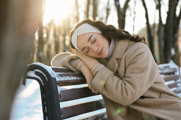 Portrait of beautiful woman resting in sunny snowy park