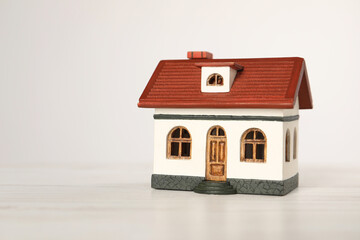 Obraz na płótnie Canvas Mortgage concept. House model on white wooden table, space for text