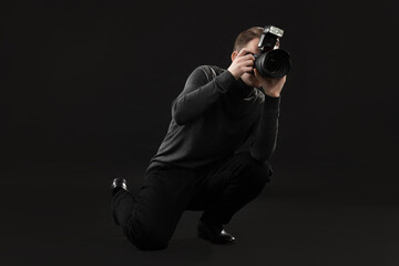 Professional photographer taking picture on black background