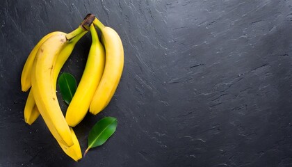 fresh yellow bananas on a black stone table top view free copy space