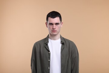 Portrait of sad man on beige background