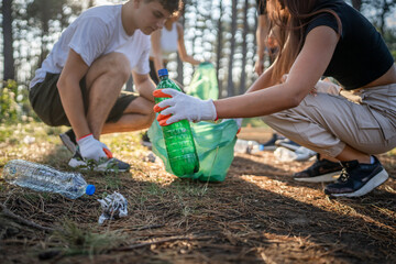 teenage friends young men women pick up waste garbage to clean forest