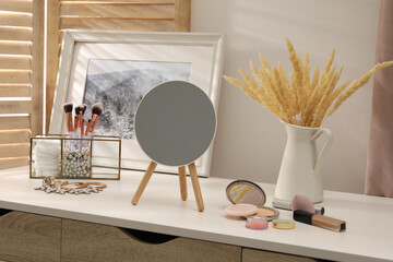 Dressing table with mirror, cosmetic products and jewelry in makeup room