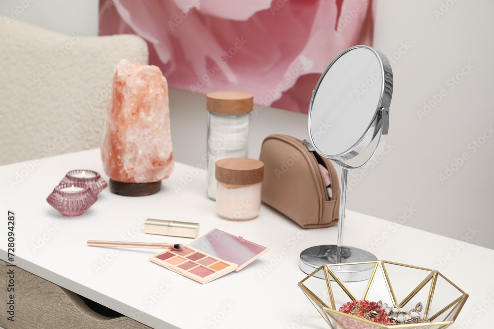 Sticker Dressing table with mirror, cosmetic products, jewelry and burning candles in makeup room