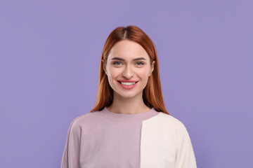 Beautiful woman with clean teeth smiling on violet background